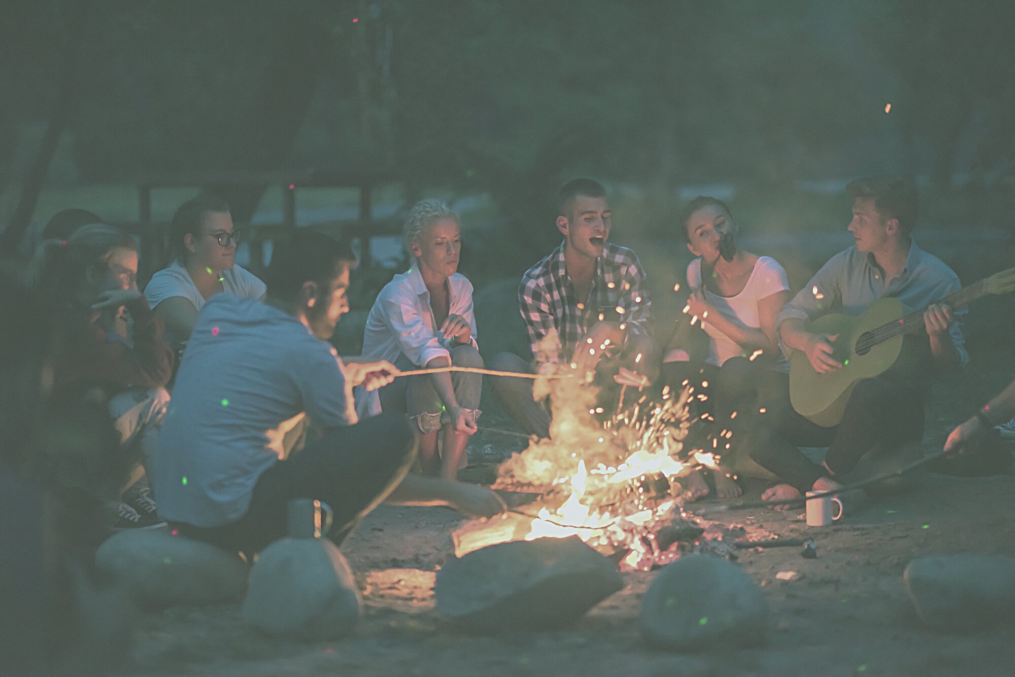 Young Friends Relaxing around Campfire